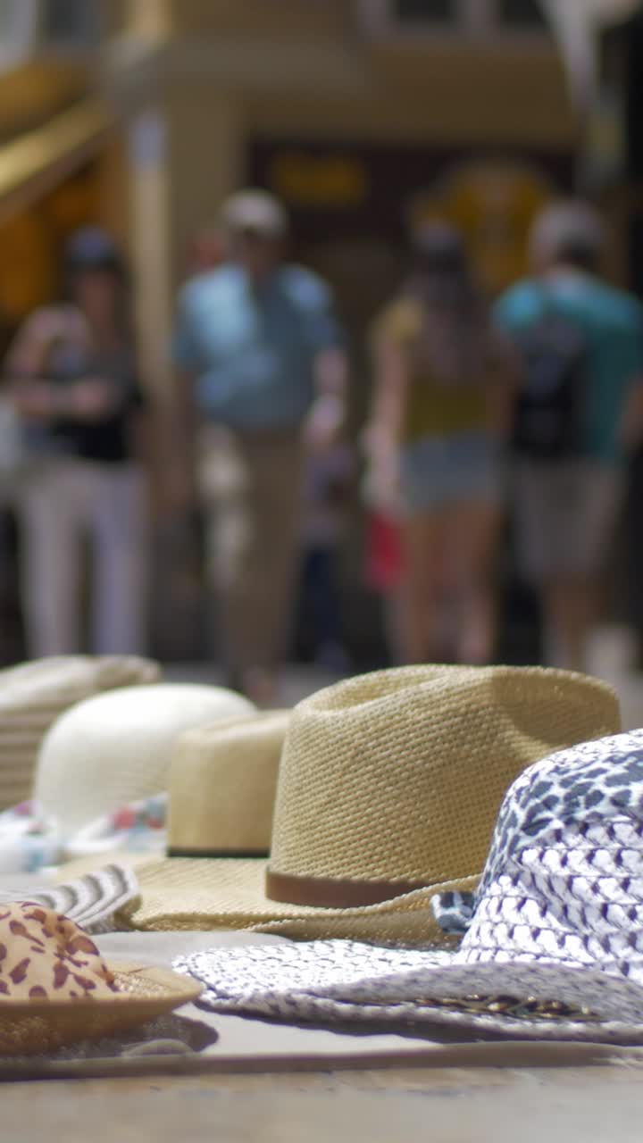 Chapéus de Palha Expostos em uma Feira ao Ar Livre com Pessoas Passando