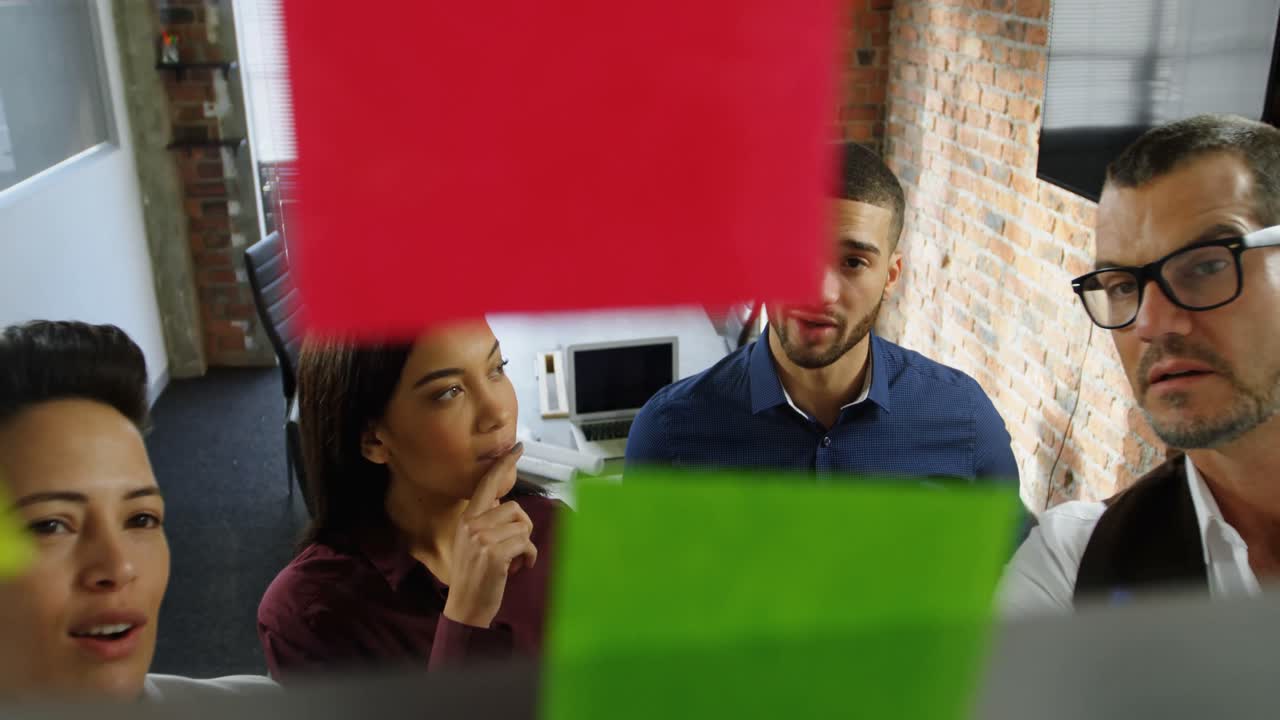 ejecutivos discutiendo sobre una nota adhesiva 4k