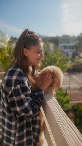 young woman with her poodle on a balcony