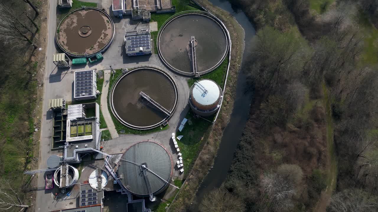 Drone aerial of water treatment plant in Milan, Italy operating under circular economy principles. Facility processes waste streams and generates renewable energy through integrated biogas systems
