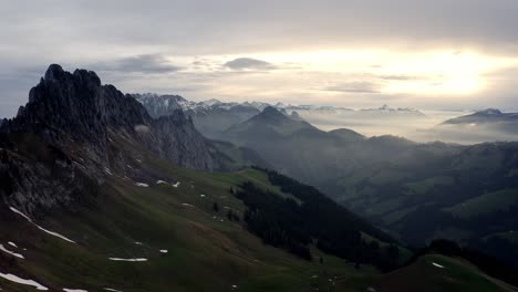 Hermosa-Cresta-Entre-Montañas-Sobre-Un-Valle-Verde-En-Un-Increíble-Amanecer-Nublado