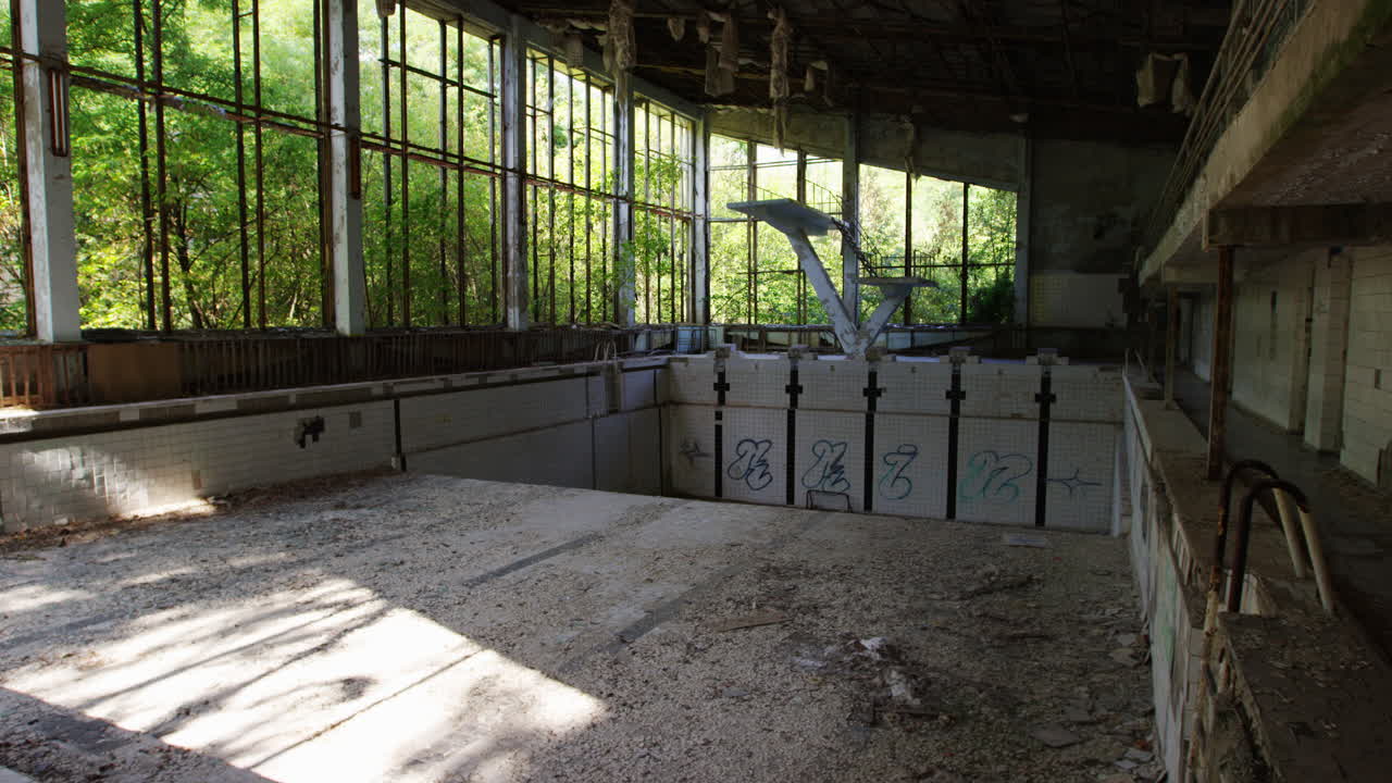 1986년 원자력 재해 동안 체르노빌 원자로 붕괴 이후 섬뜩한 침묵이 프리피아트의 버려진 수영장을 둘러싸고 있습니다.