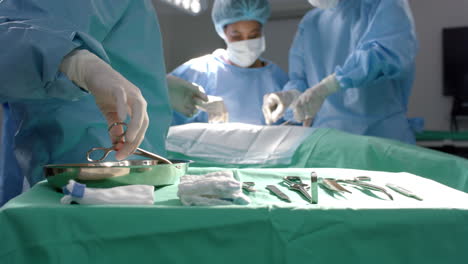 diverse surgeons operating on patient using surgical instruments in operating theatre, slow motion