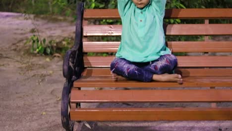 young kid meditating at wood bench in traditional dress at evening from different angles