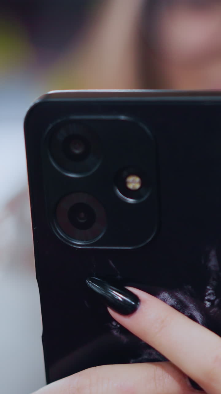 primer plano de la mano involucrada con el teléfono inteligente, con la cara ligeramente borrosa en el fondo y luces bokeh suaves y vibrantes, centrarse en la interacción de la tecnología moderna en el entorno de comunicación digital