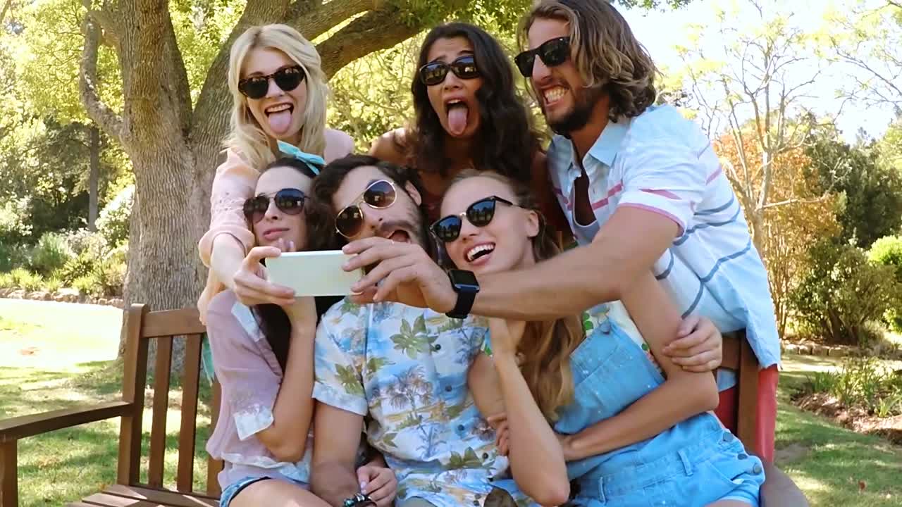 amigos tomando selfies en el parque