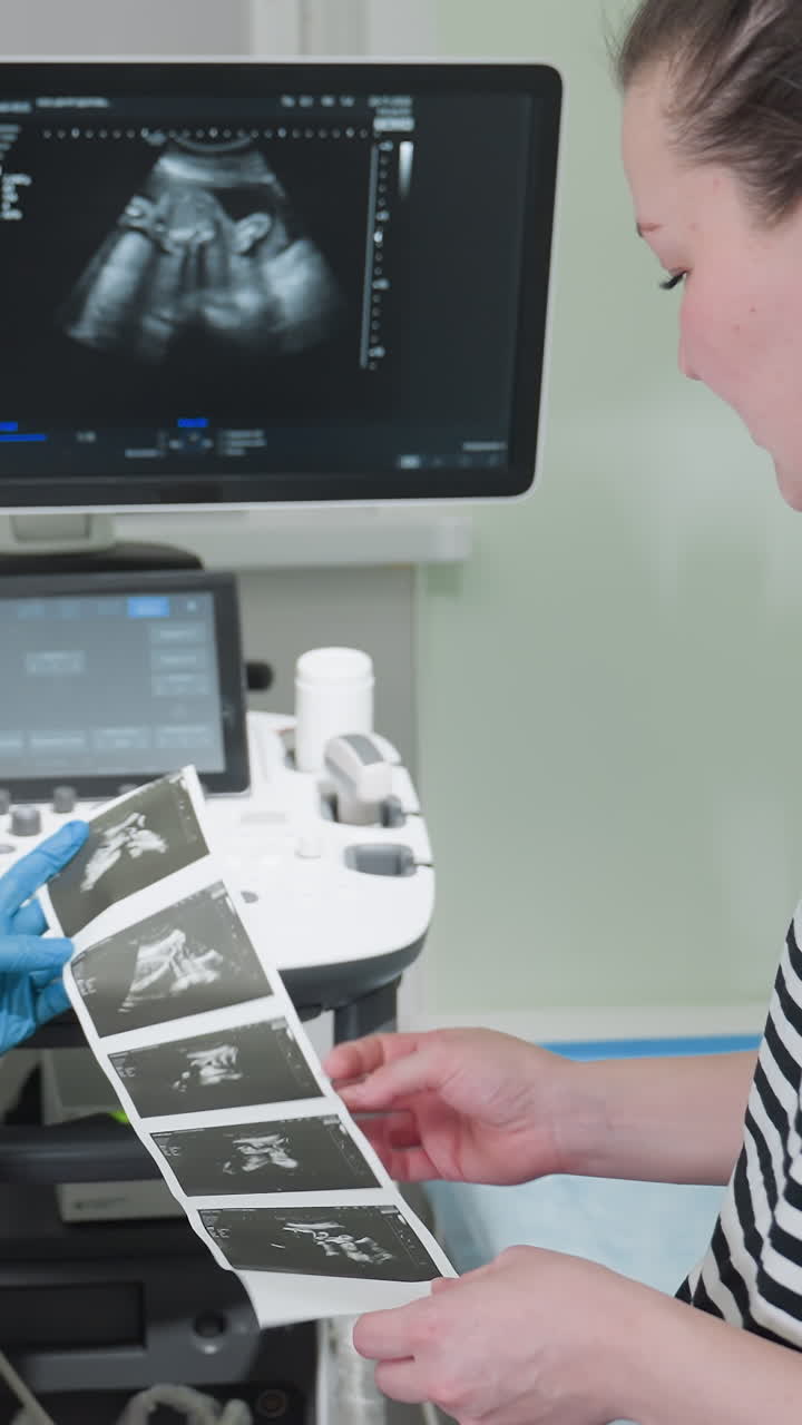 pregnant white woman reviewing ultrasound prints in clinic as sonographer explains images, monitor shows fetal profile, hands hold sequential film strip, warm hopeful atmosphere, patient examines