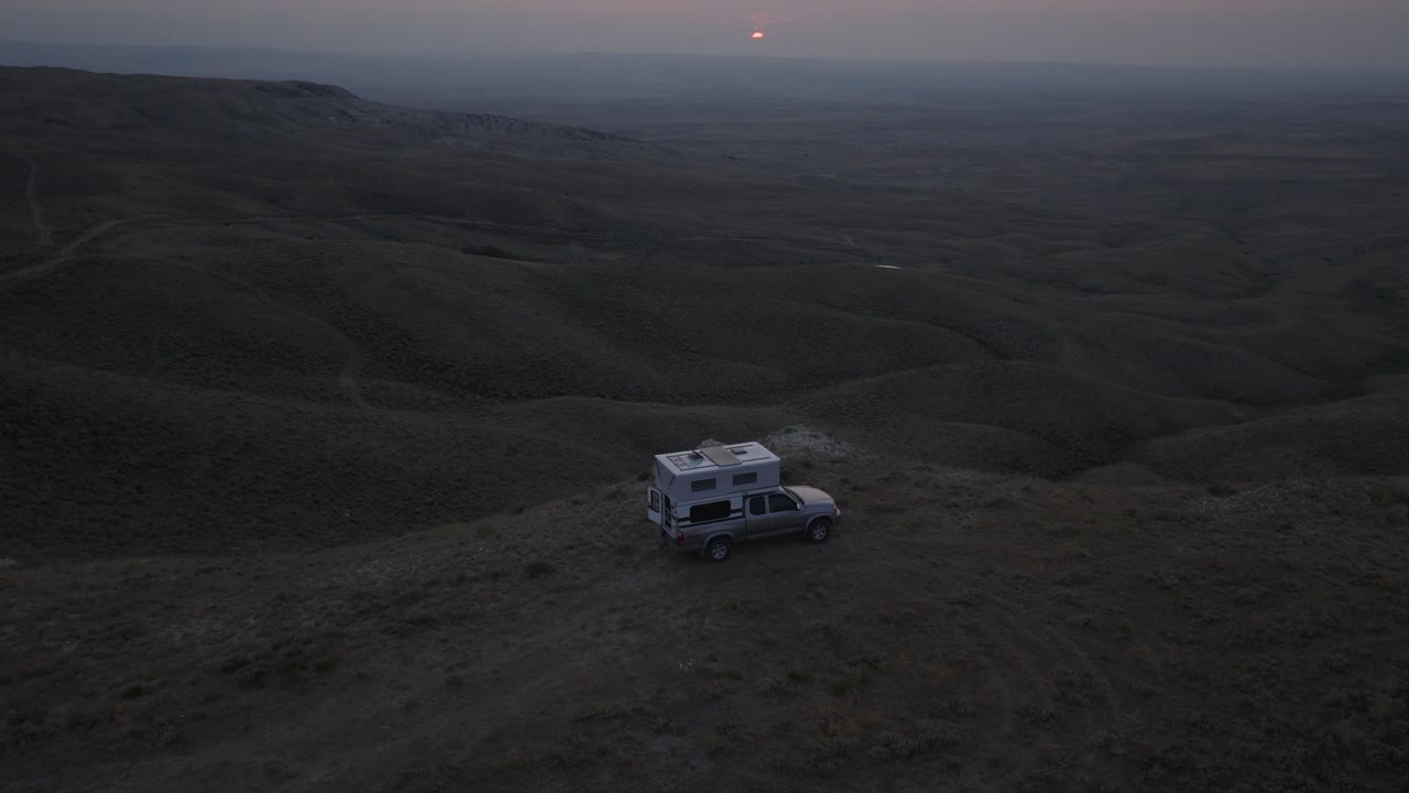 camión con camper con vistas al vasto paisaje de la pradera al anochecer con la luz suave desvaneciéndose