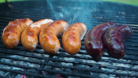 primer plano de salchicha a la parrilla en barbacoa con carbón