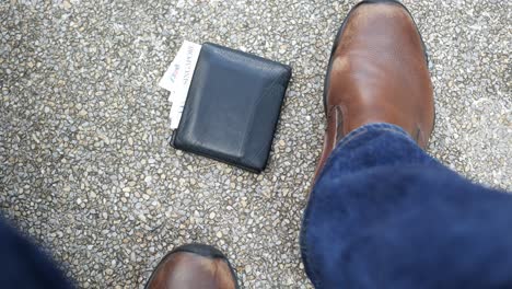la billetera cae del bolsillo en un parque .