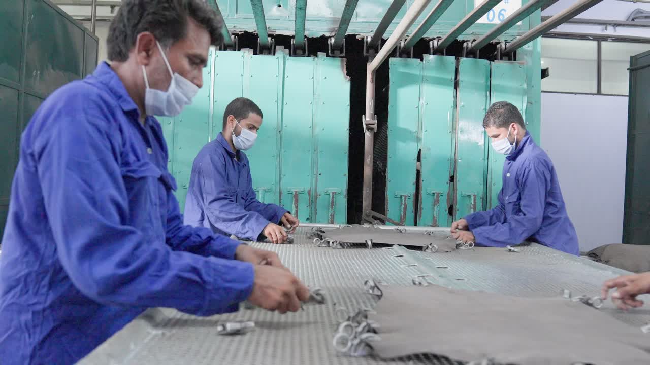 Leather stretching process drying frame by factory workers in Islamabad Pakistan