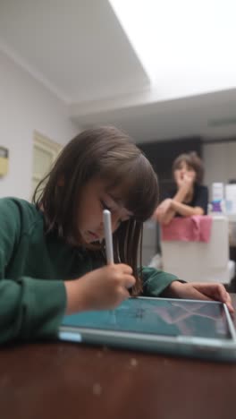 child drawing on tablet in kitchen