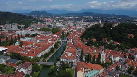 cinematic 4k aerial view of ljubljana old town and ljubljana castle with mountains in the background