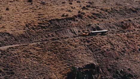 Truck-Slowly-Climbing-the-Mountain-Transporting-Pipeline-for-Oil-and-Natural-Gas,-Construction-on-the-mountain-road