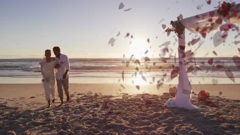 animation of hearts over happy married african american couple at beach