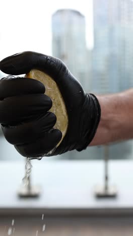 squeezing lemon in black gloves