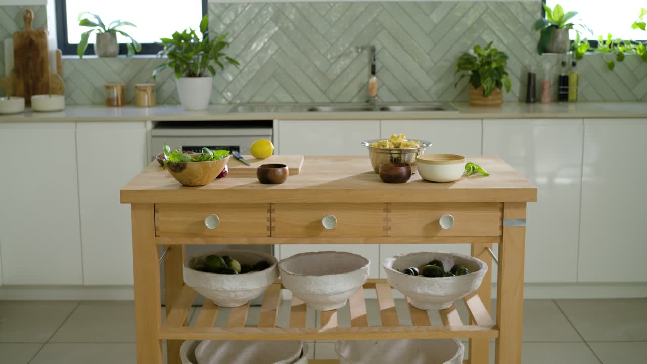 La camera si allontana lentamente, rivelando un’isola da cucina in legno con un limone su un tagliere per mostrare la cucina
