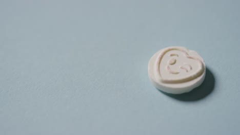 파란색 배경에 로맨틱한 윙크하는 이모티콘으로 하트 사탕을 손에 들고