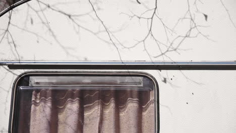 close up of tree branches shadow over abandoned van, switzerland