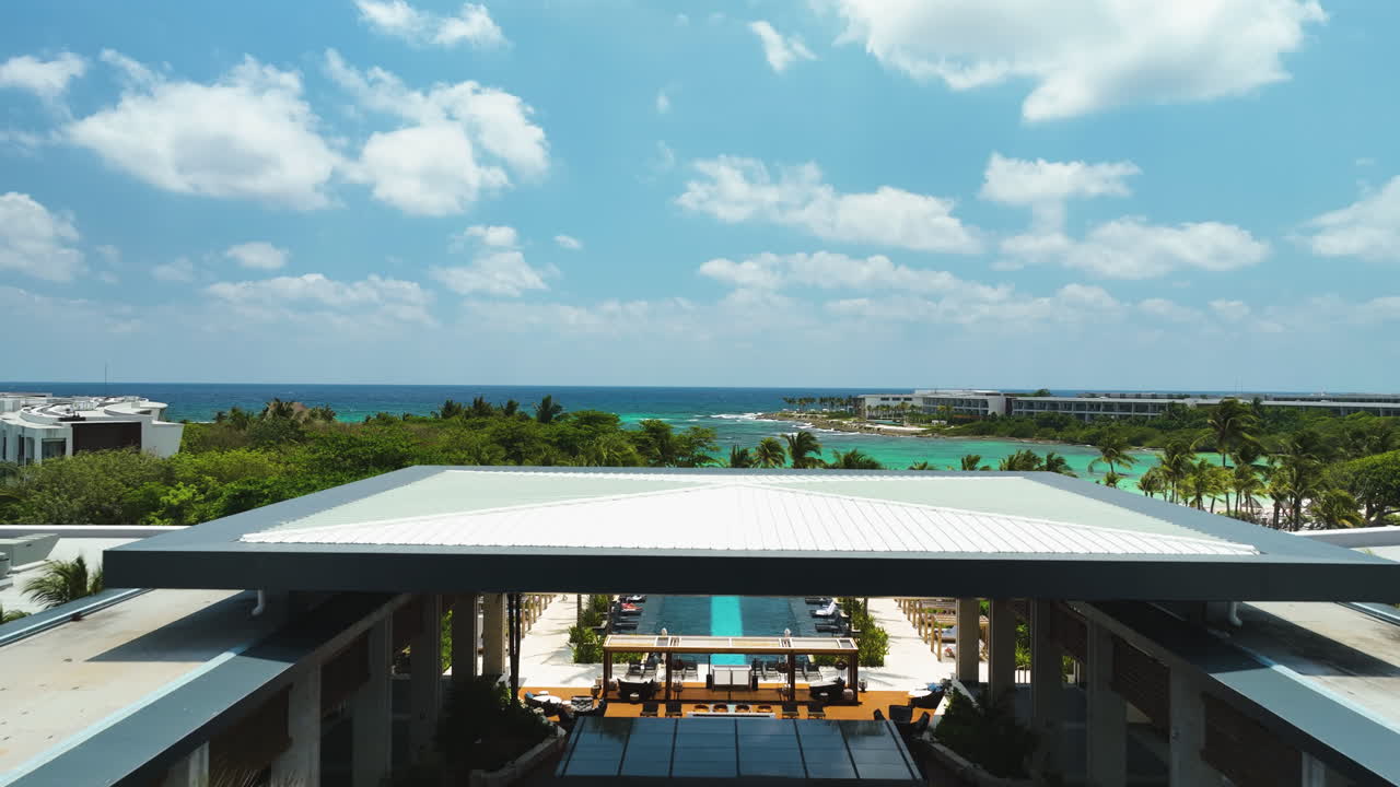 Drone rising over the Conrad hotel, a beach and blue sea. in sunny Tulum, Mexico