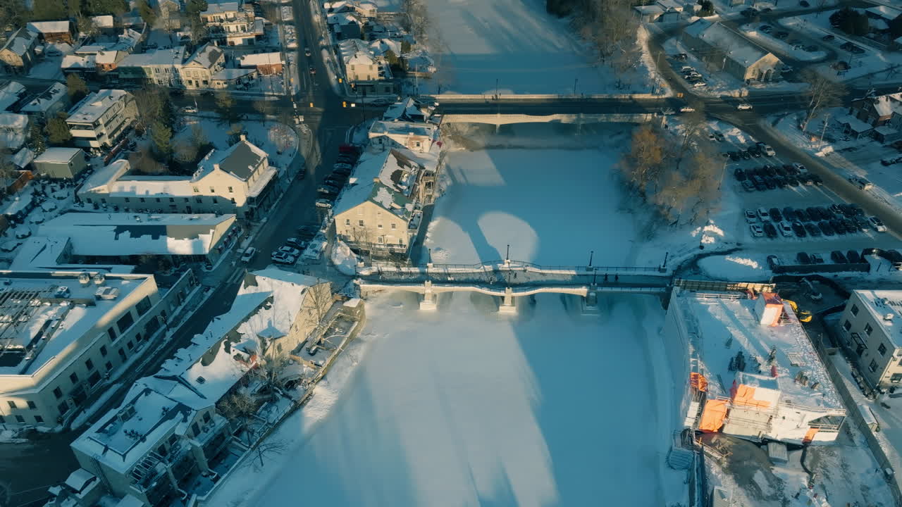 Luftfoto af sneklædte Elora, Ontario, der viser flod og bro om vinteren.
