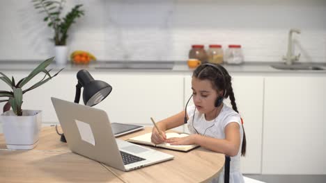 Kids-distance-learning.-Cute-little-girl-using-laptop-at-home.-Education,-online-study,-home-studying,-technology,-science,-future,-distance-learning,-homework,-schoolgirl-children-lifestyle-concept.