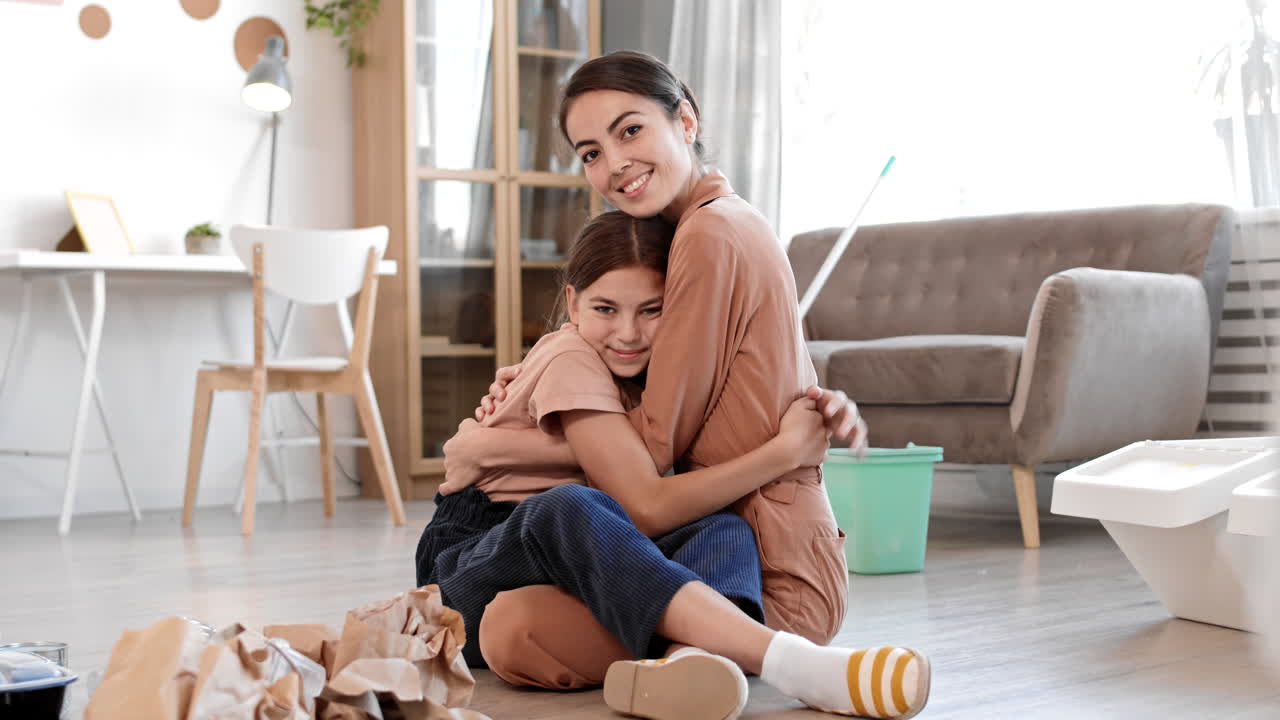 madre e hija abrazándose durante la limpieza del apartamento