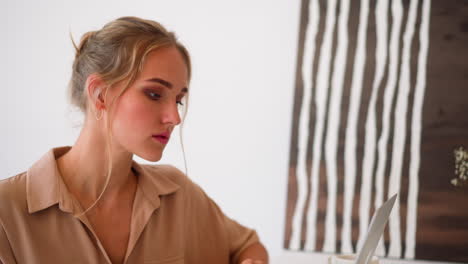 Focused-woman-looks-at-screen-of-laptop-making-calculations