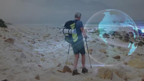Man hiking beach with pack and trekking poles, showing hologram globe with tech data streams