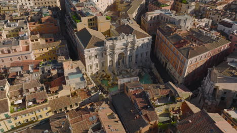 Vista-De-ángulo-Alto-De-La-Exclusiva-Fuente-De-Trevi.-Famosa-Fuente-Barroca-Con-Esculturas-Y-Agua-Turquesa.-Incline-Hacia-Arriba-La-Revelación-De-Los-Tejados-En-El-Casco-Antiguo.-Roma,-Italia