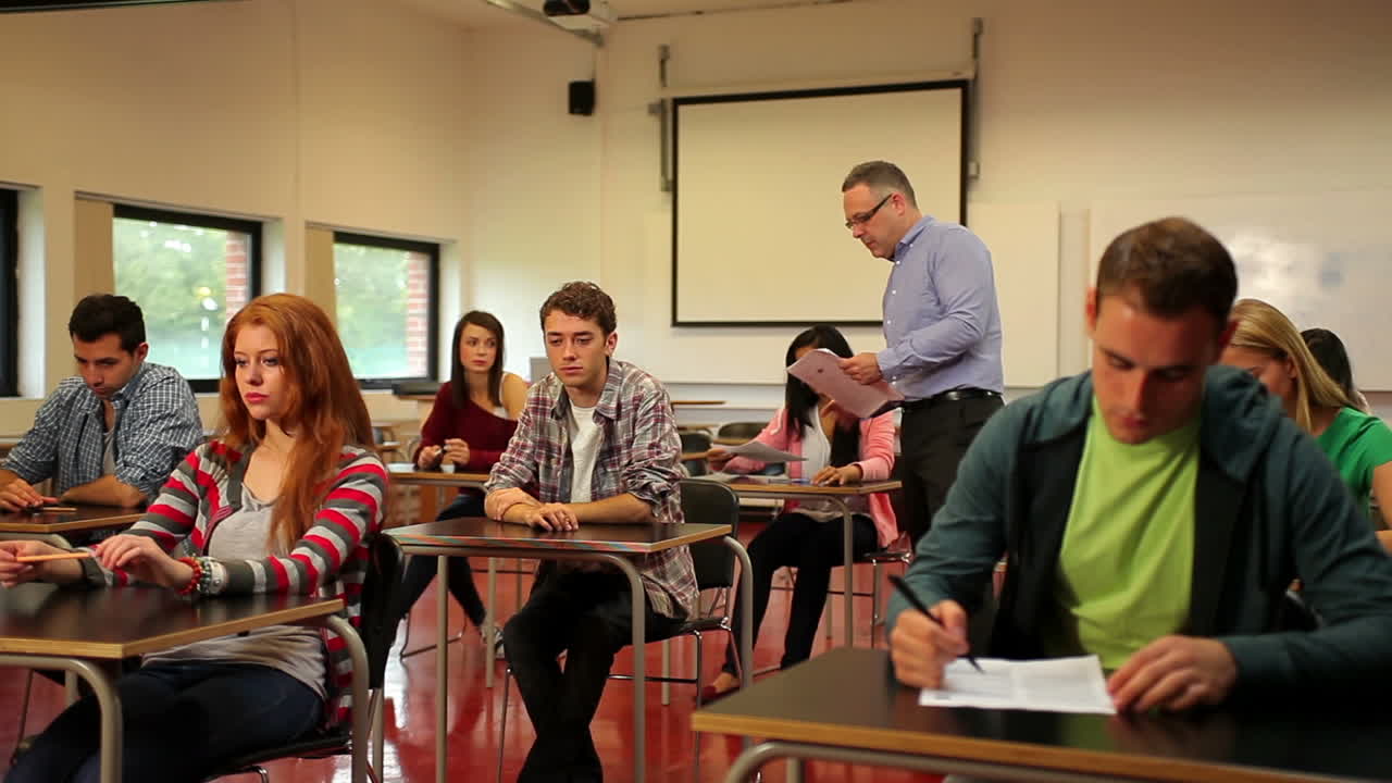 Lecturer handing out papers to his students