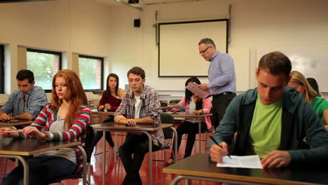 lecturer handing out papers to his students