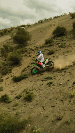 el motociclista baja cuesta abajo con el rastro de polvo fpv. el piloto hábil maniobra el vehículo moderno a través de la zona fuera de carretera en las carreras. sentido de poder y libertad