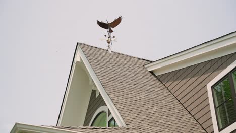 Goose-wind-vane-atop-rood,-wide-shot