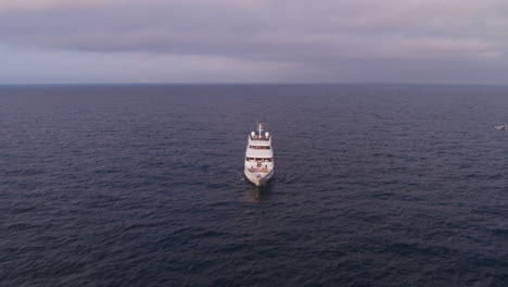 descending aerial shot with tilt up of a secluded boat alone at sea