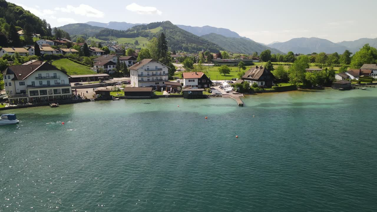 Attersee i Østrig med landsby ved søen, turkisblåt vand og alpine bjerge i Salzkammergut-regionen. Naturskønt sommerlandskab og populært østrigsk rejsemål