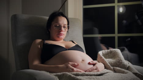 baby moving in the womb, pregnant woman relaxing at night