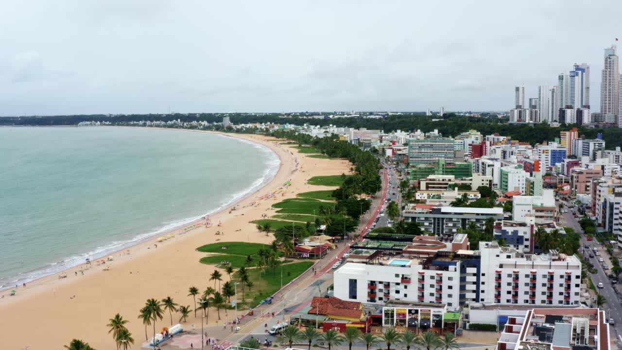 Trucking left aerial drone shot of the colorful tropical beach capital city of Joao Pessoa in Paraiba, Brazil from the Tambaú neighborhood on an overcast morning