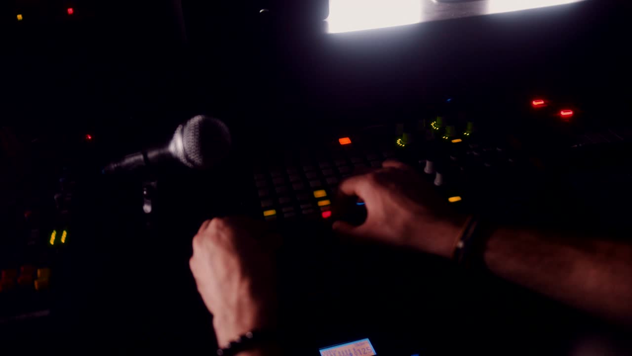 Sound engineer working on sound control panel and producing music