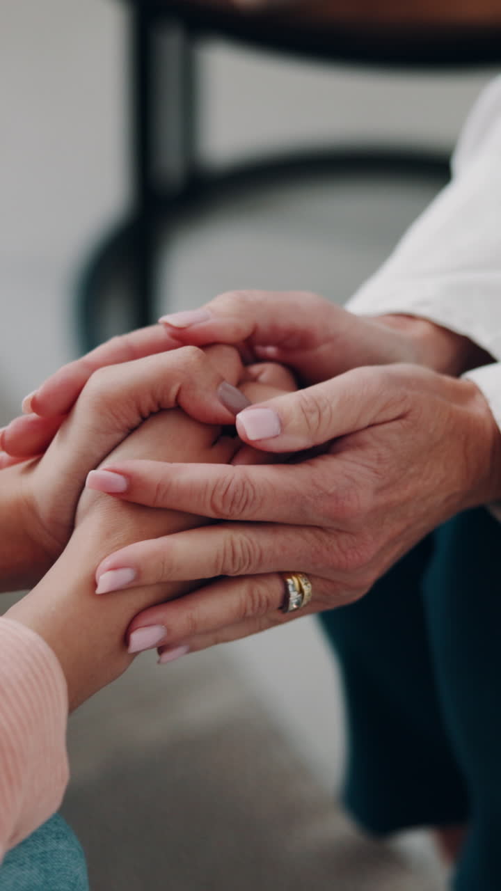 Primer plano de dos personas tomándose de las manos en señal de consuelo y apoyo