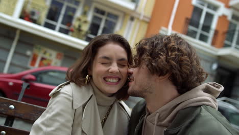 Love-couple-feeling-happy-together-outdoor.-Man-whispering-to-woman-on-street.