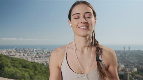 Woman-putting-on-earphones-in-city-of-Barcelona.-Girl-listening-music-in-earbuds