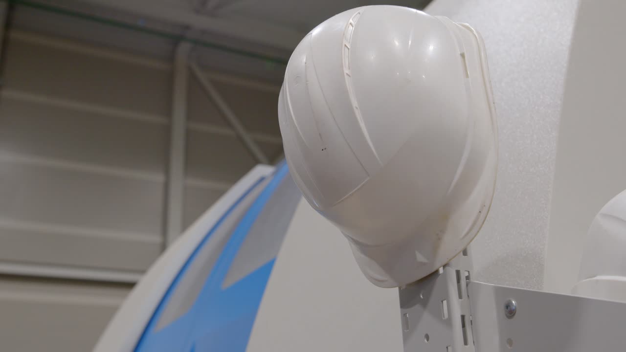 el casco de un trabajador descansa sobre una máquina en una fábrica