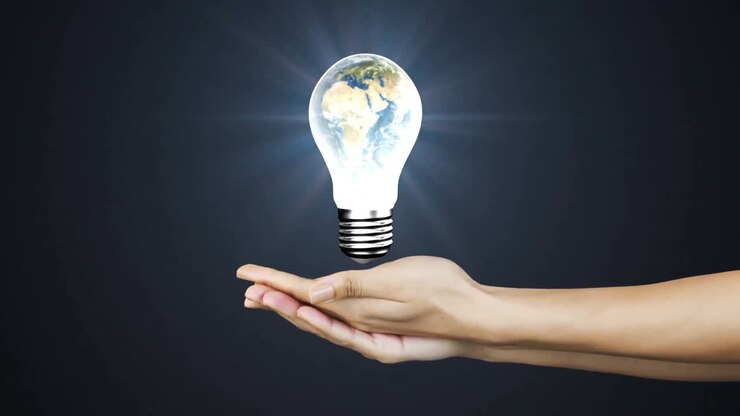 Mano che tiene una lampadina luminosa con la Terra all'interno, creando un concetto di animazione