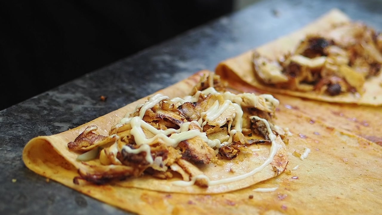 Close-up of Sauce Being Drizzled on a Chicken Shawarma Wrap