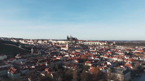 slow aerial ascend over red prague city building rooftops, clear sky day