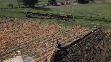 plowing of land with tractor on farm and birds flying