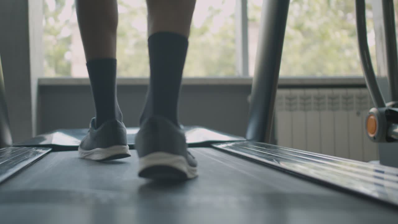 Rear view of man's feet running.