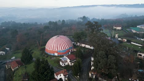 Órbita-Aérea-Alrededor-De-La-Carpa-Del-Circo-Benposta-Rodeada-De-árboles-Altos-En-Ourense,-España