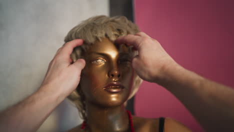 stylist adjusting a wig on a mannequin